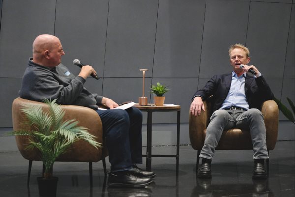 Two men sit in chairs